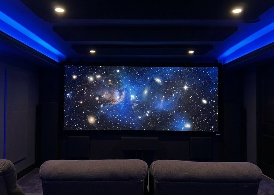 Salle de cinéma maison avec écran de projection, fauteuils inclinables et éclairage d'ambiance bleu