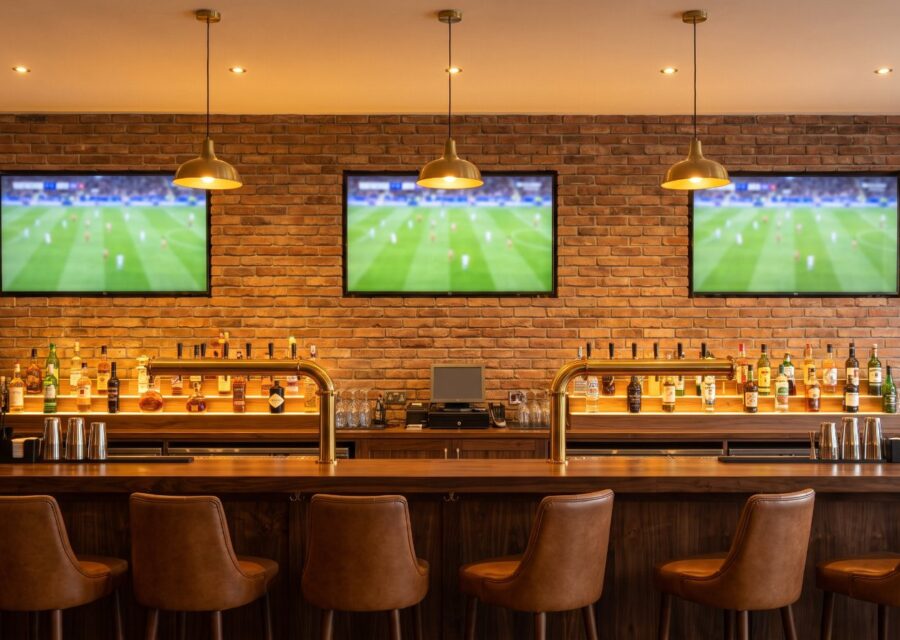 Bar sportif avec téléviseurs muraux sur un mur de brique