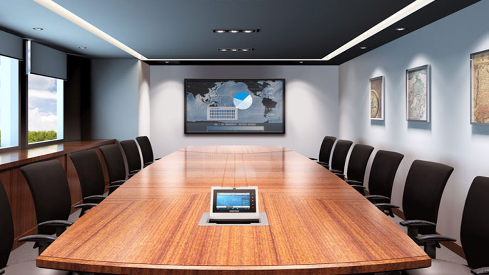 Salle de conférence avec écran mural et table de réunion